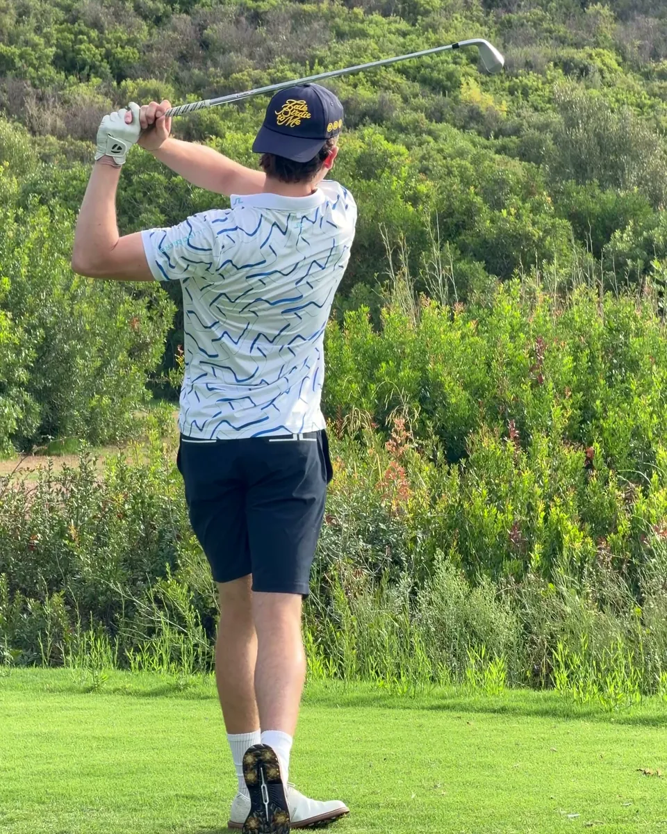A golfer holding his finish at the end of a full swing.